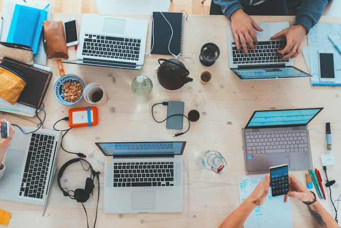 Team sequenziert eine KI-Roadmap an einem Tisch voller Laptops