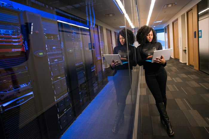 Compliance-Verantwortliche mit Tablet neben einem Server-Rack